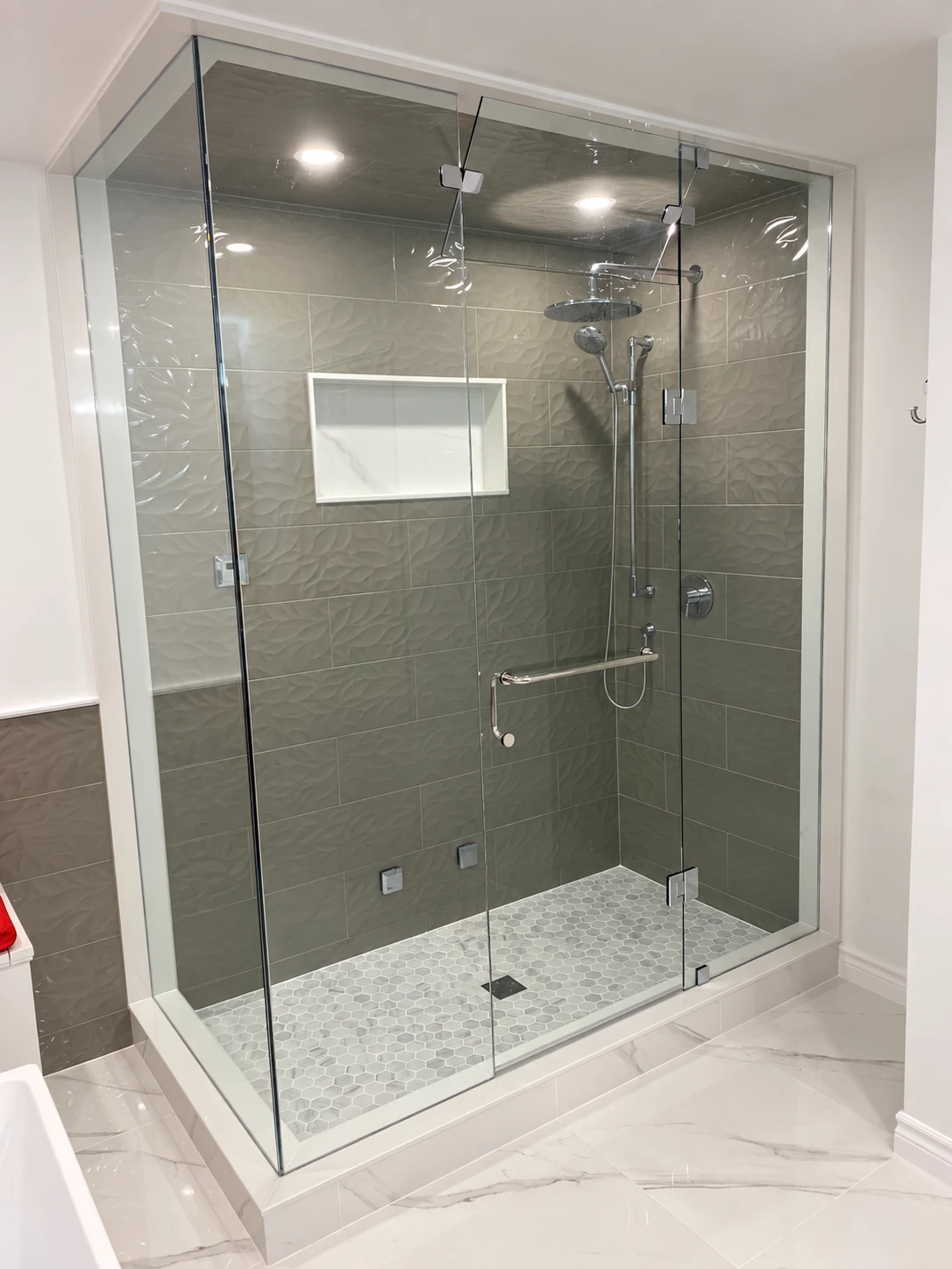 Frameless glass shower enclosure with chrome hardware